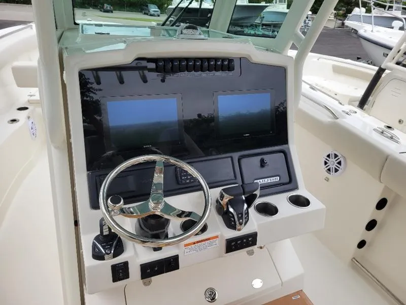 Slide: The Image of 2025 Sailfish 272 CC boat dashboard with dual screens and steering wheel. - 20