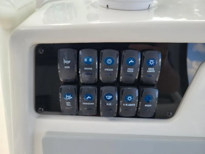 Slide: The Image of Control panel of a 2025 Sailfish 241 CC boat with various switches. - 21