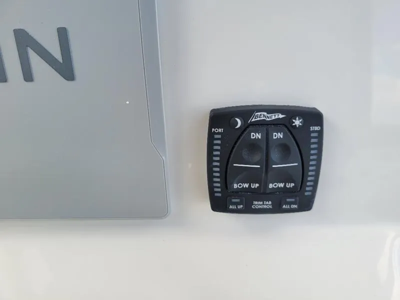Slide: The Image of Bennett trim tab control on 2025 Sailfish 241 CC boat dashboard. - 23