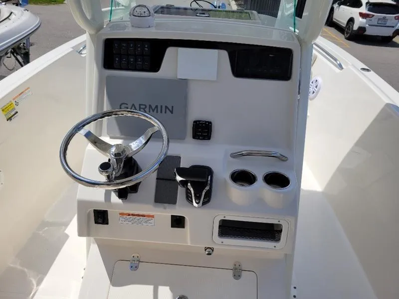 Slide: The Image of 2025 Sailfish 241 CC boat console with Garmin navigation system and steering wheel. - 8