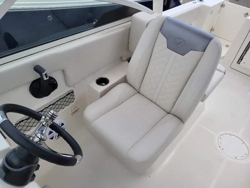 Slide: The Image of 2025 Sailfish 236 DC boat interior with open storage compartment and portable toilet. - 10