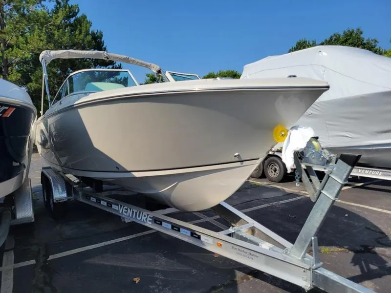 Slide: The Image of 2025 Sailfish 236 DC boat on trailer in parking lot, sunny day. - 3