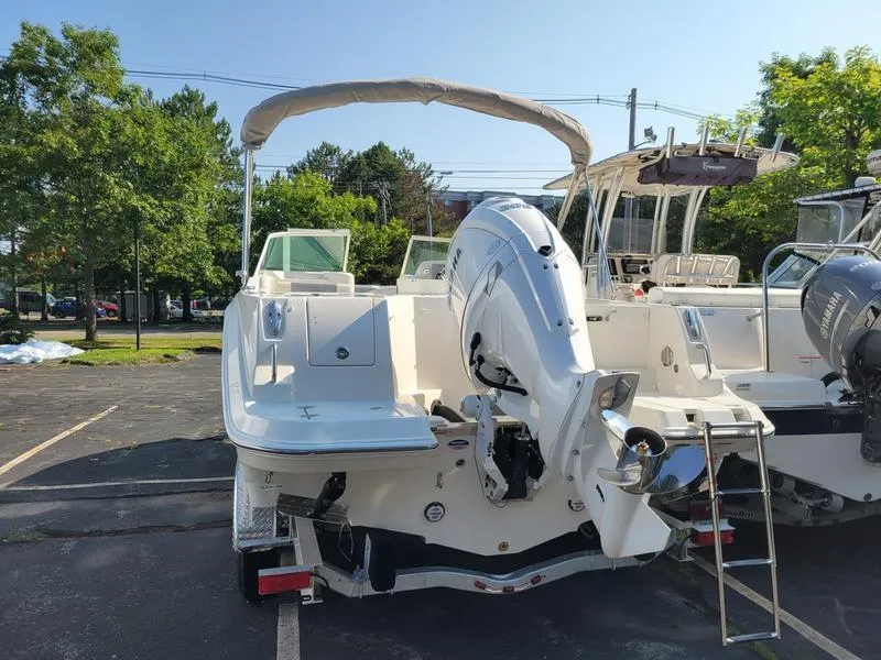 Slide: The Image of 2025 Sailfish 236 DC boat with outboard motor in a parking lot. - 5