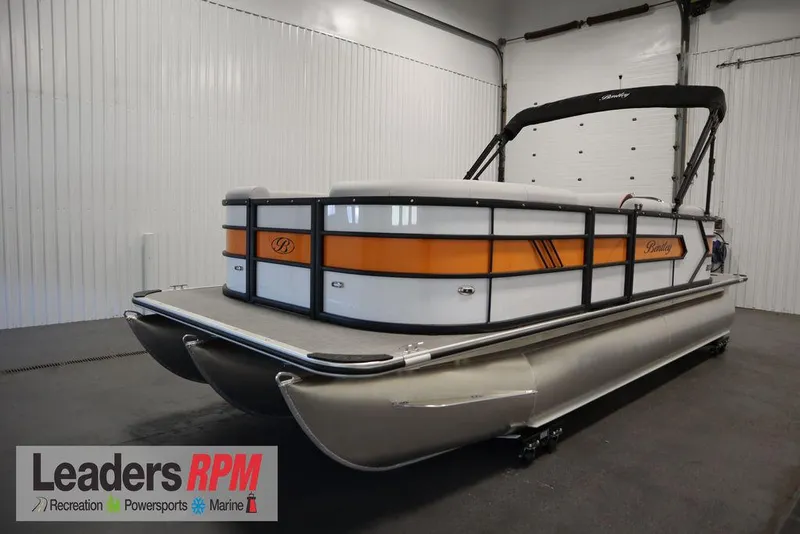 Slide: The Image of 2024 Bentley Pontoons 203 Bolt Tri-Toon in showroom, featuring sleek design and vibrant orange accents. - 0