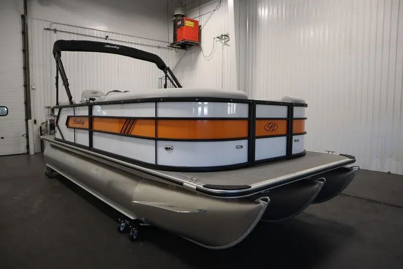 Slide: The Image of 2024 Bentley Pontoons 203 Bolt Tri-Toon in a showroom, featuring sleek design and vibrant accents. - 1