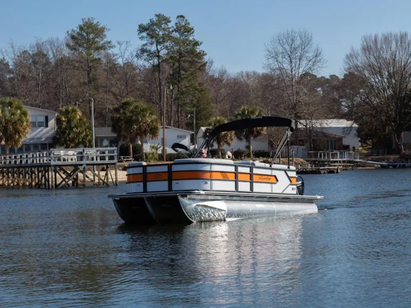 Slide: The Image of 2024 Bentley Pontoons 203 Bolt Tri-Toon on a serene lake near waterfront homes. - 42