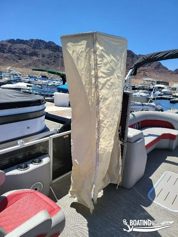 Slide: The Image of 2021 Bennington L25 Stern Radius pontoon boat interior with canopy, docked at marina. - 10