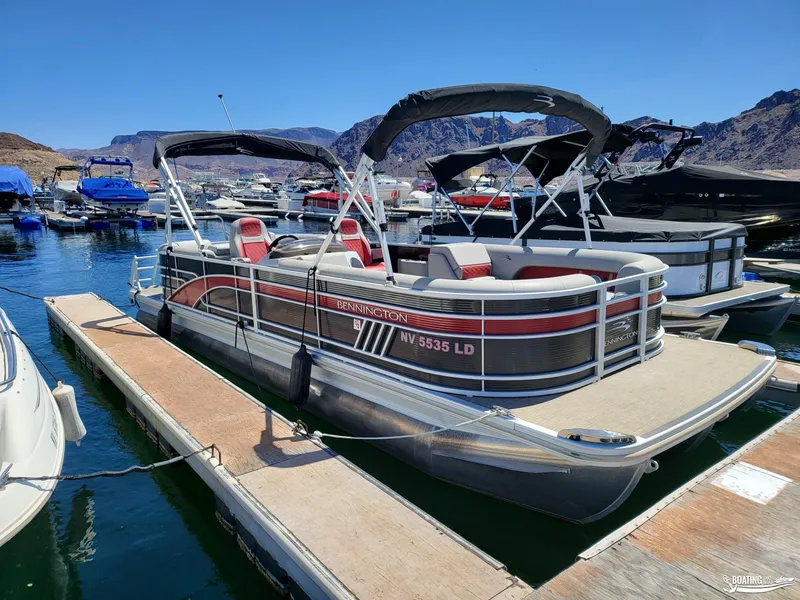 Slide: The Image of 2021 Bennington L25 Stern Radius pontoon boat docked at a marina. - 2