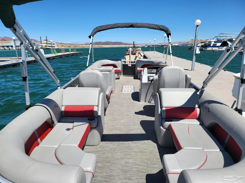 Slide: The Image of 2021 Bennington L25 Stern Radius pontoon boat docked, featuring spacious seating and modern design. - 3