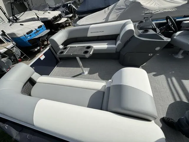 Slide: The Image of 2024 Bennington 22 SSR pontoon boat interior with plush seating and table. - 10