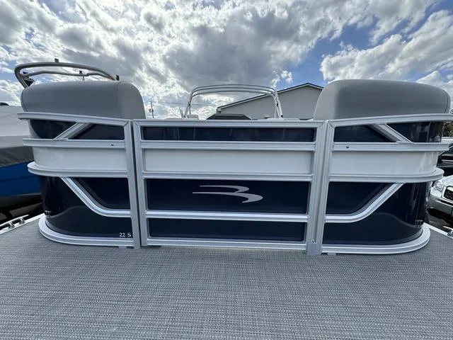 Slide: The Image of 2024 Bennington 22 SSR pontoon boat under a cloudy sky. - 2