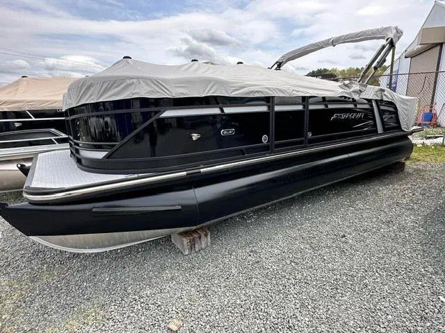 Slide: The Image of 2024 Starcraft SLS 3 Q DH pontoon boat covered and parked on gravel. - 1