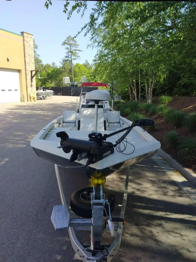 Slide: The Image of 2024 Ranger RB210 boat on a trailer in a parking lot. - 2