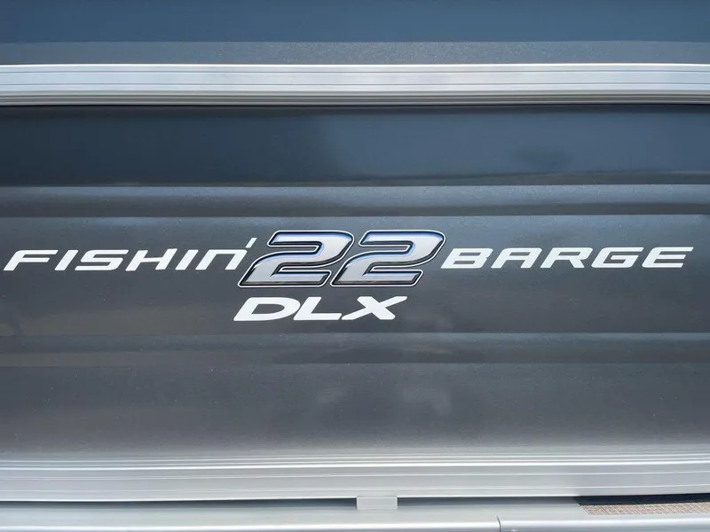 Slide: The Image of 2024 Sun Tracker Fishin' Barge 22 DLX logo on boat exterior. - 2
