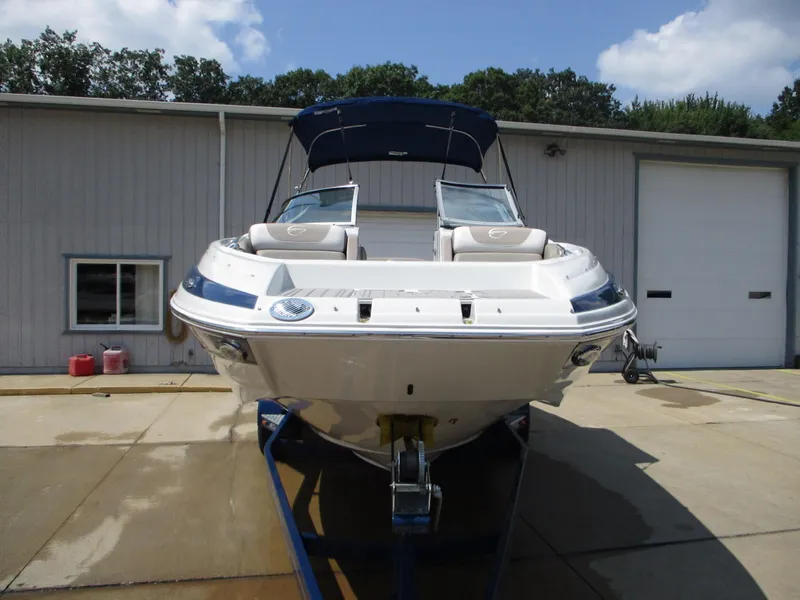 Slide: The Image of 2019 Crownline Eclipse E255 boat on trailer, front view, parked outside. - 2