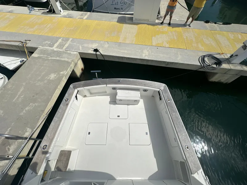 Slide: The Image of 1999 Ocean 45 Super Sport boat docked at a marina, view of the spacious deck. - 11