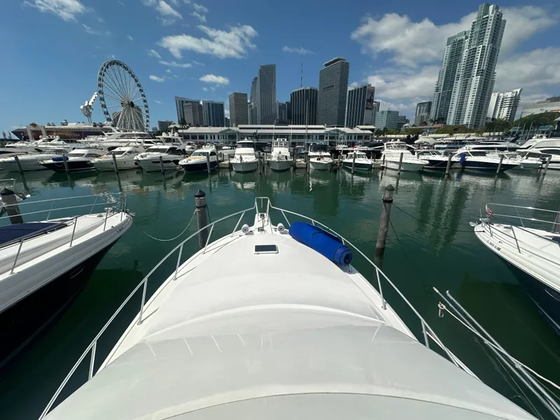 Slide: The Image of 1999 Ocean 45 Super Sport yacht docked in a marina with city skyline and Ferris wheel. - 12