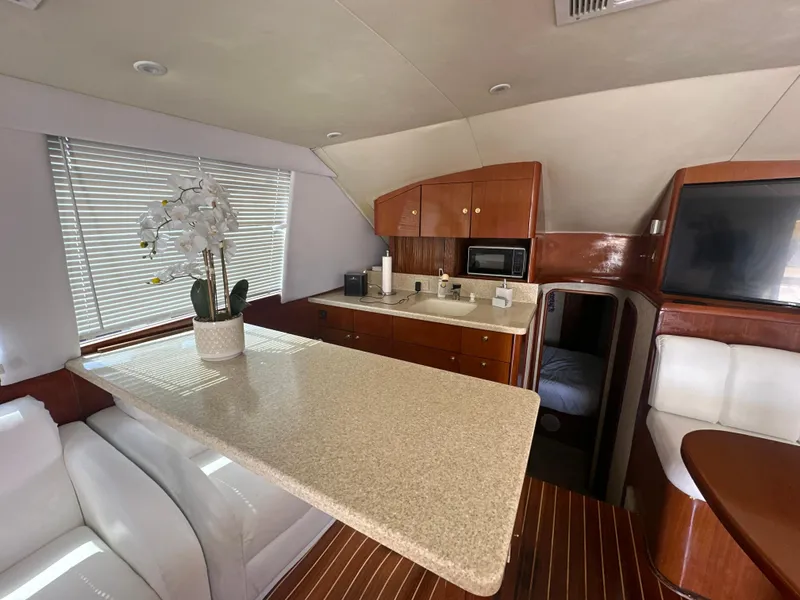 Slide: The Image of 1999 Ocean 45 Super Sport yacht interior with modern kitchen and dining area. - 16