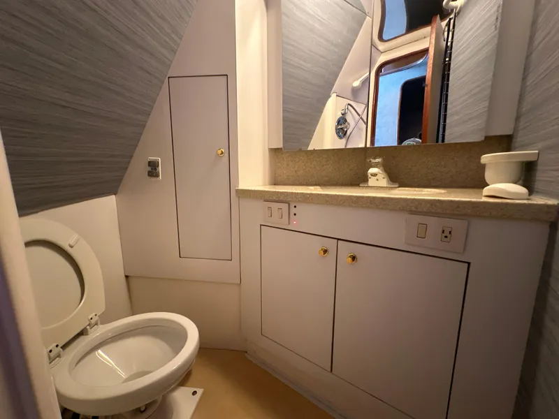 Slide: The Image of 1999 Ocean 45 Super Sport yacht bathroom with toilet, sink, and storage cabinets. - 18