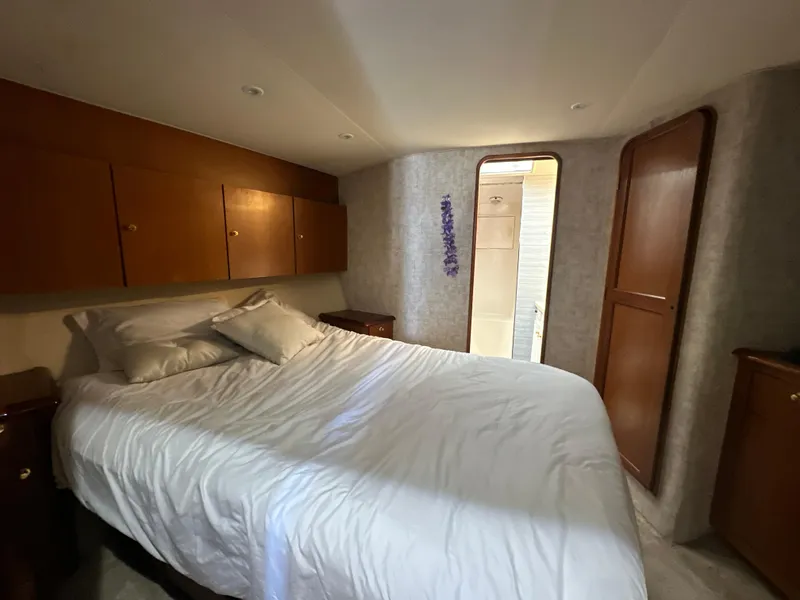 Slide: The Image of 1999 Ocean 45 Super Sport yacht bedroom with cozy bed and wooden cabinets. - 20