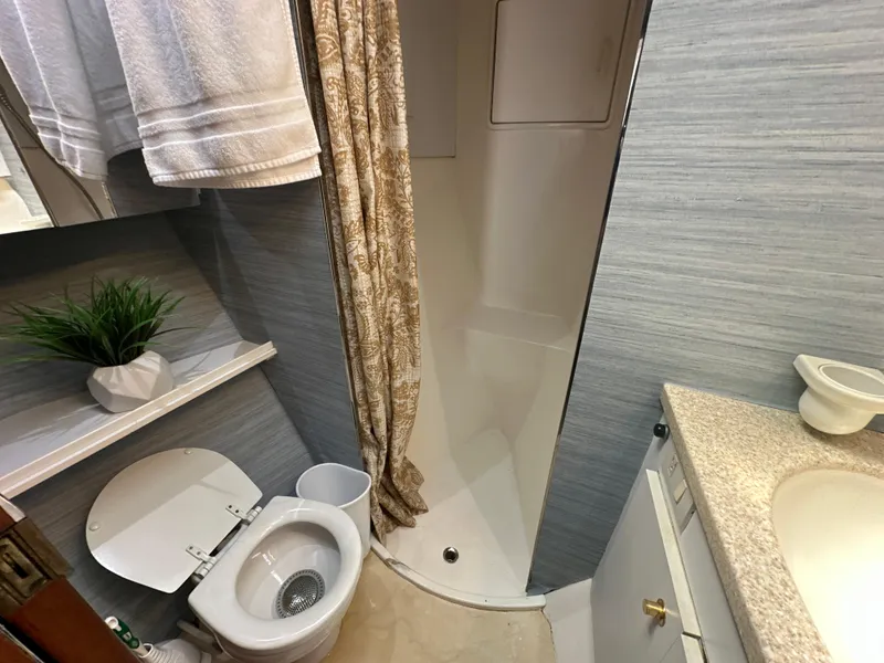 Slide: The Image of 1999 Ocean 45 Super Sport boat bathroom with shower, toilet, and sink. - 21