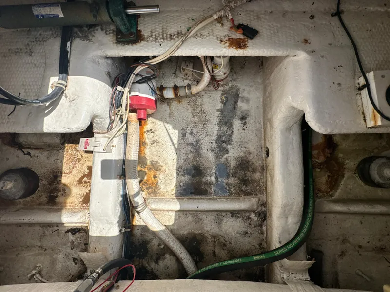 Slide: The Image of 1999 Ocean 45 Super Sport boat engine compartment with visible wiring and hoses. - 22