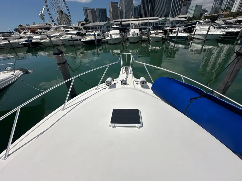 Slide: The Image of Bow view of 1999 Ocean 45 Super Sport yacht docked in a marina with city skyline. - 28