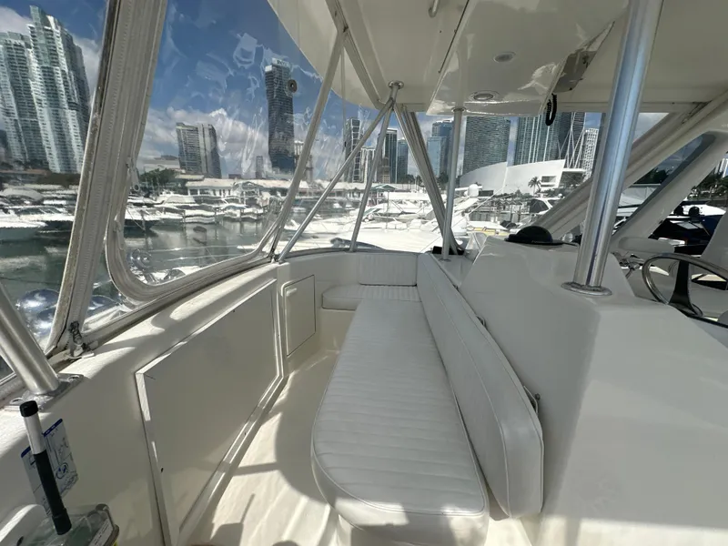 Slide: The Image of 1999 Ocean 45 Super Sport yacht interior with white seating and marina view. - 8