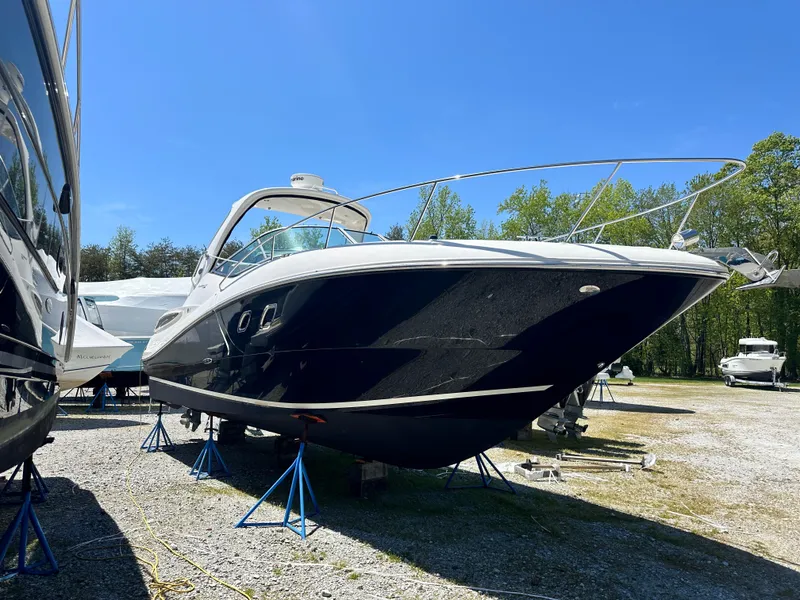 The Image of 2012 Sea Ray 330 Sundancer boat on stands in a sunny outdoor setting. - 0
