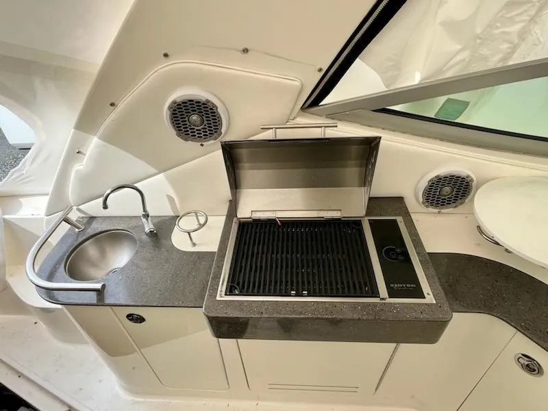 Slide: The Image of 2012 Sea Ray 330 Sundancer boat kitchenette with grill, sink, and speakers. - 10