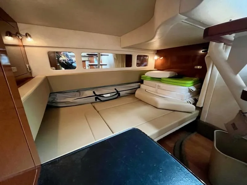 Slide: The Image of 2012 Sea Ray 330 Sundancer cabin interior with beige seating and storage. - 21