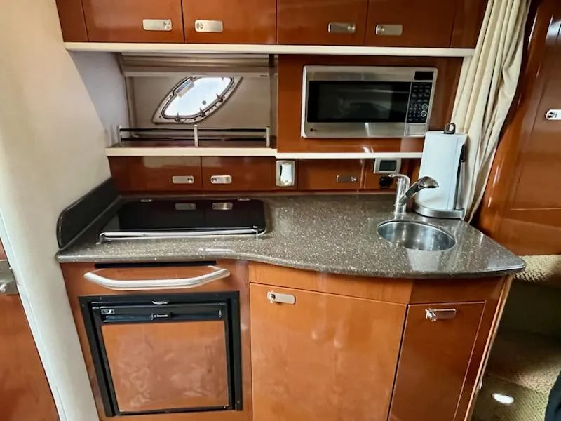 Slide: The Image of Kitchen area of 2012 Sea Ray 330 Sundancer with microwave, sink, and compact fridge. - 22