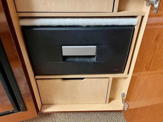 Slide: The Image of Cabinet interior of 2012 Sea Ray 330 Sundancer with built-in storage compartments. - 25