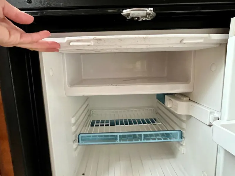 Slide: The Image of Open refrigerator inside a 2012 Sea Ray 330 Sundancer boat, showing empty shelves. - 28
