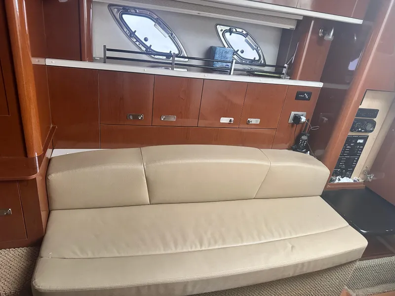 Slide: The Image of Interior of 2012 Sea Ray 330 Sundancer with beige seating and wooden cabinetry. - 30