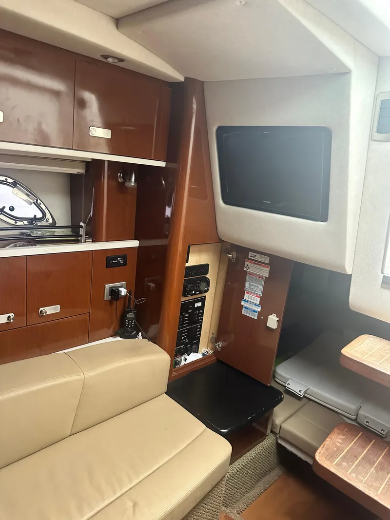 Slide: The Image of Interior of 2012 Sea Ray 330 Sundancer with beige seating and wooden cabinetry. - 31