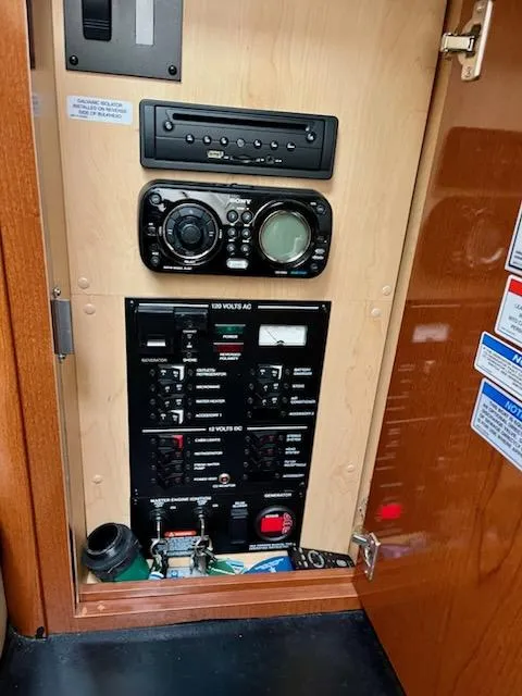 Slide: The Image of Control panel inside 2012 Sea Ray 330 Sundancer boat, featuring audio system and electrical switches. - 32