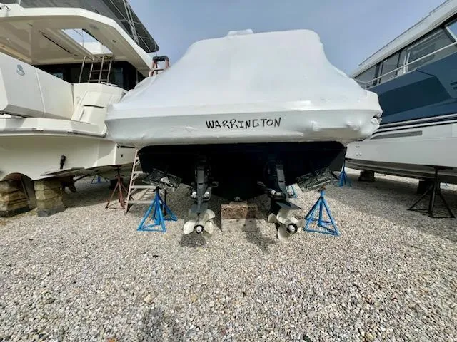 Slide: The Image of Covered 2012 Sea Ray 330 Sundancer boat on stands, labeled "Warrington," in a boatyard. - 43