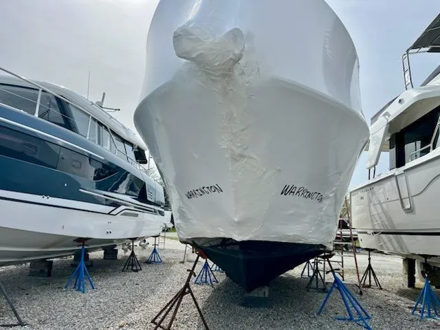 Slide: The Image of 2012 Sea Ray 330 Sundancer boat in storage, wrapped and elevated on stands. - 45