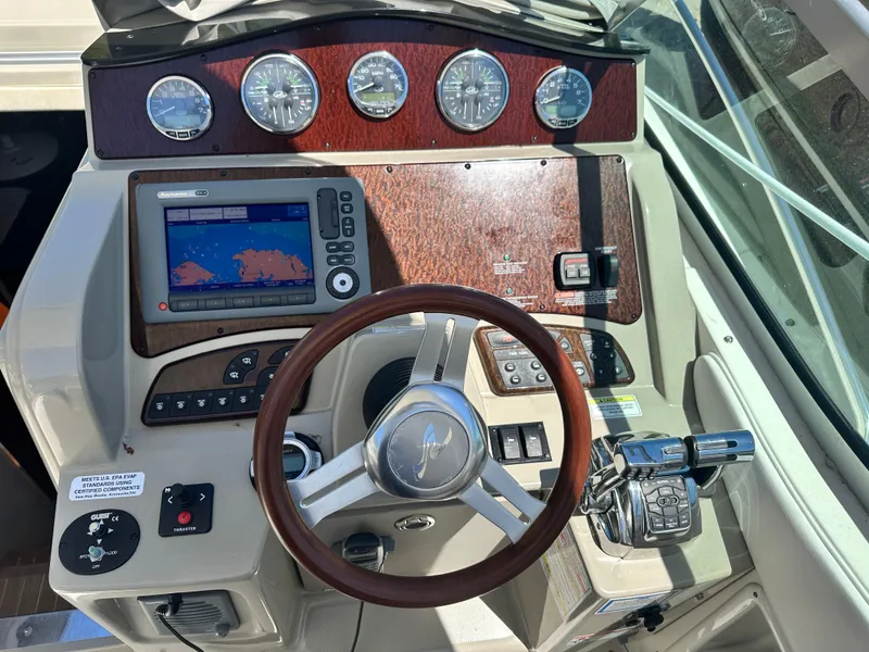 Slide: The Image of 2012 Sea Ray 330 Sundancer helm with GPS, gauges, and wood accents. - 7
