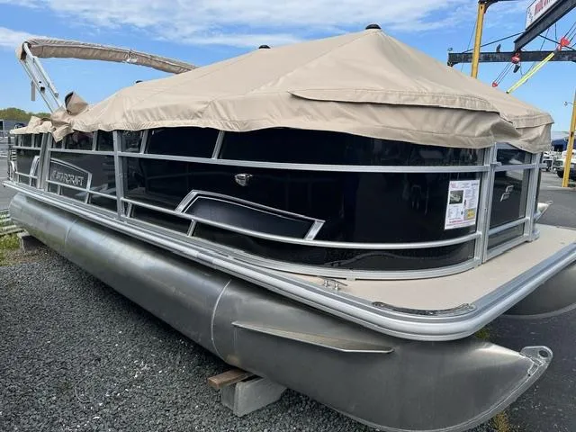 Slide: The Image of 2024 Starcraft EX 22 FD pontoon boat with beige cover on gravel lot. - 1