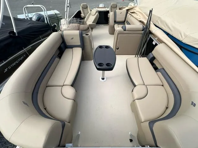 Slide: The Image of 2024 Starcraft EX 22 FD pontoon boat with spacious seating and central table. - 2