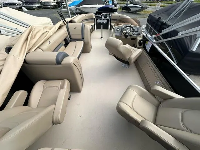 Slide: The Image of 2024 Starcraft EX 22 FD pontoon boat interior with beige seating and helm. - 3