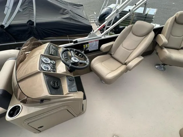 Slide: The Image of 2024 Starcraft EX 22 FD boat interior with beige captain's chair and control console. - 4