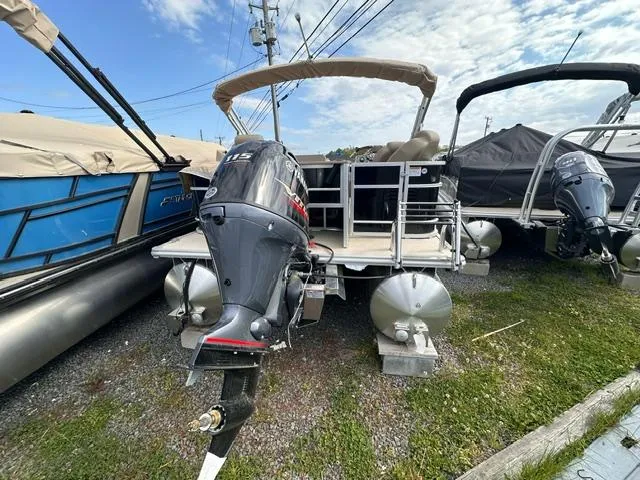 Slide: The Image of 2024 Starcraft EX 22 FD pontoon boat with outboard motor, parked on gravel lot. - 5