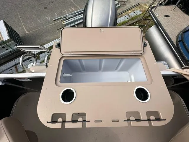 Slide: The Image of 2024 Starcraft EX 22 FD boat with open storage compartment and cup holders. - 6