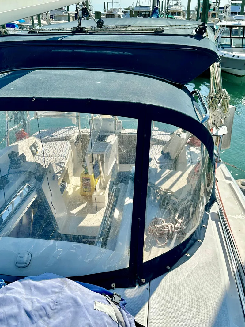 Slide: The Image of 2014 Hunter 33 sailboat cockpit with clear enclosure, docked at marina. - 13