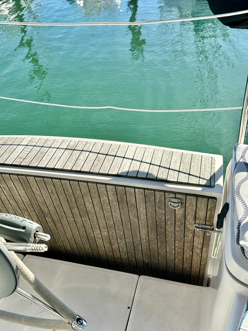 Slide: The Image of Hunter 33 sailboat deck, 2014 model, with wooden finish and view of calm water. - 14