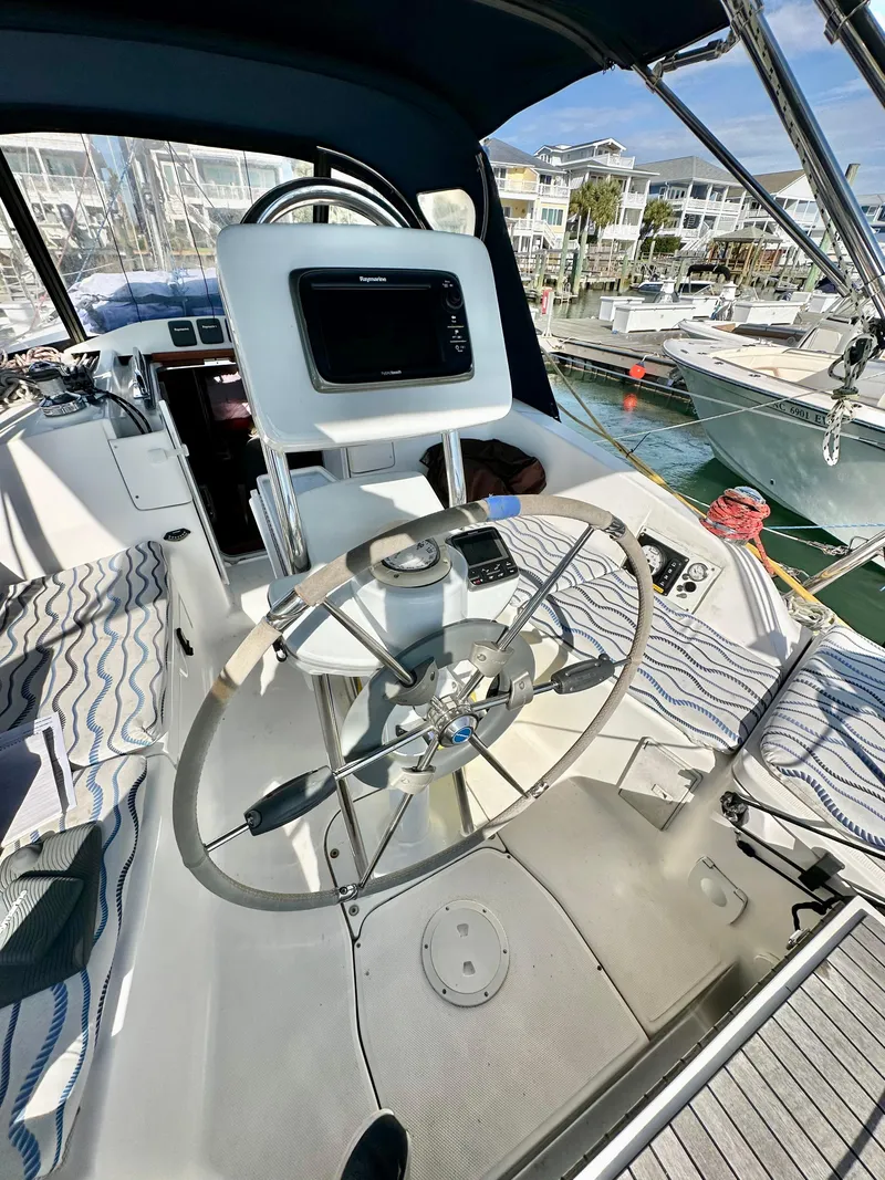 Slide: The Image of 2014 Hunter 33 sailboat cockpit with steering wheel and navigation equipment. - 15