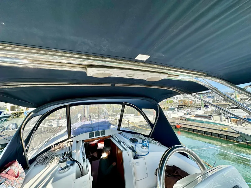 Slide: The Image of 2014 Hunter 33 sailboat cockpit with blue canopy and marina view. - 16